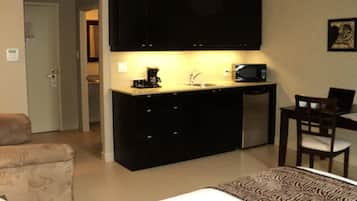 Escritorio, cortinas opacas, tabla de planchar con plancha