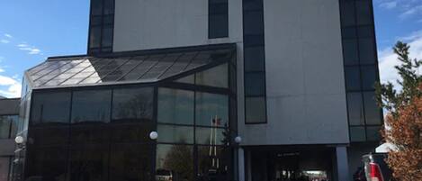 Un moderno edificio de hotel con fachada de vidrio y un letrero que dice "HOTEL" en la parte superior.