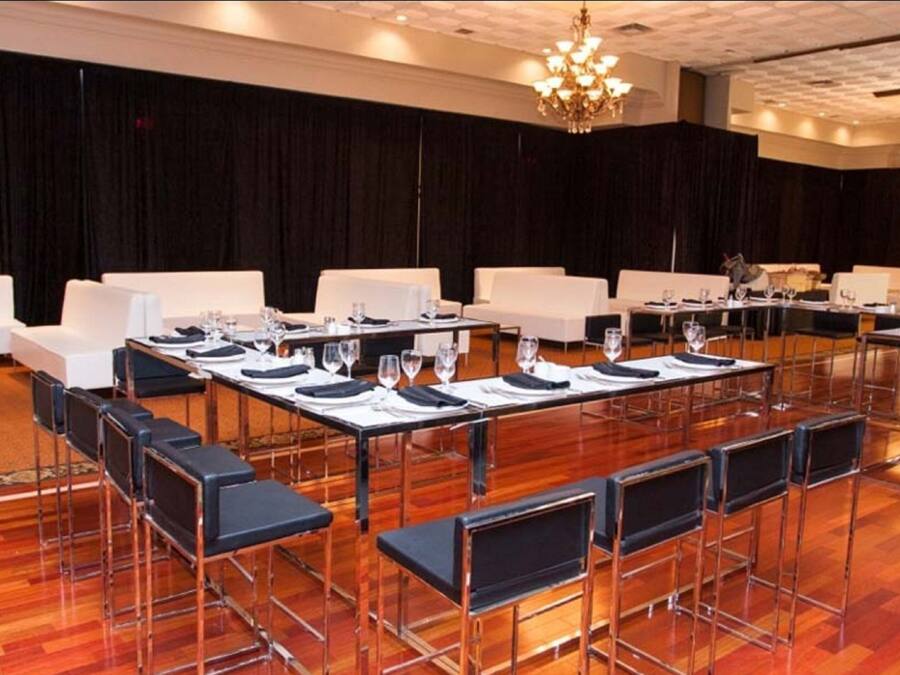 A conference room with long tables, chairs, and a chandelier.