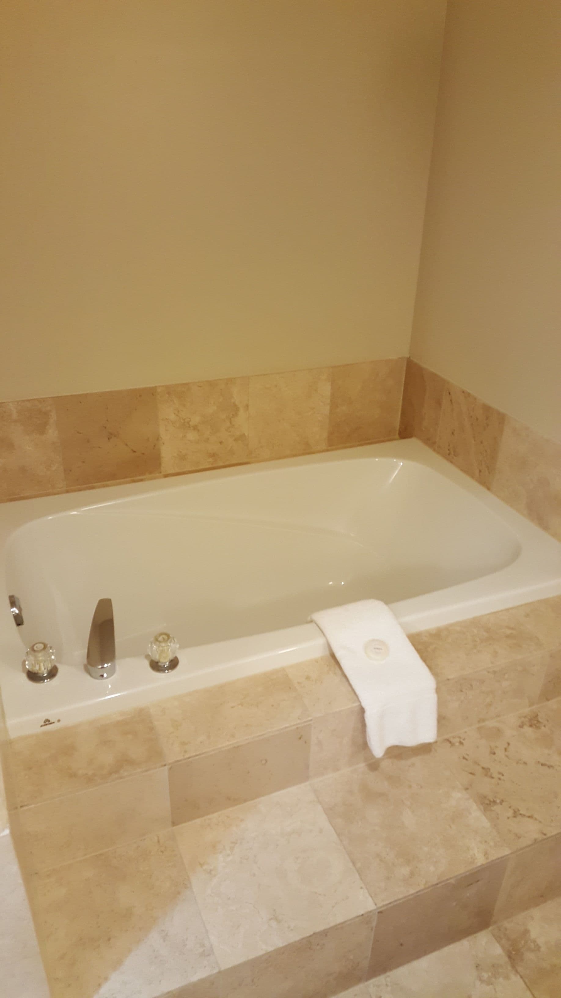 A bathroom with a bathtub, a towel rack, and a shower area.