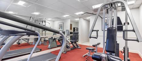 A gym with treadmills, weight machines, and exercise equipment.