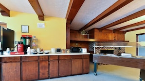 Una cocina con armarios de madera, una encimera con diversos electrodomésticos y un horno de ladrillo.