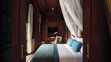A bedroom with a large bed, a desk, and a chair.