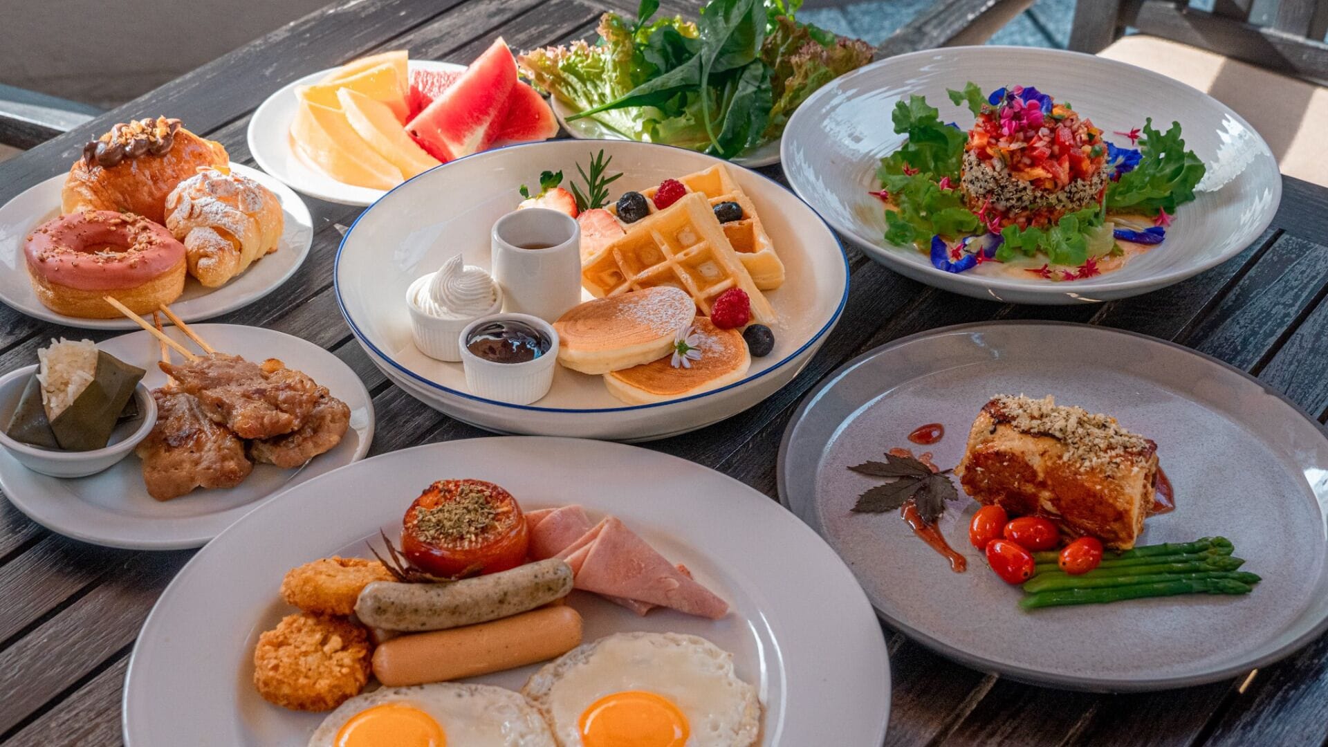 A variety of breakfast dishes on a wooden table.