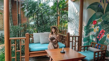 Une terrasse en bois avec un canapé bleu, une table en bois et des chaises.