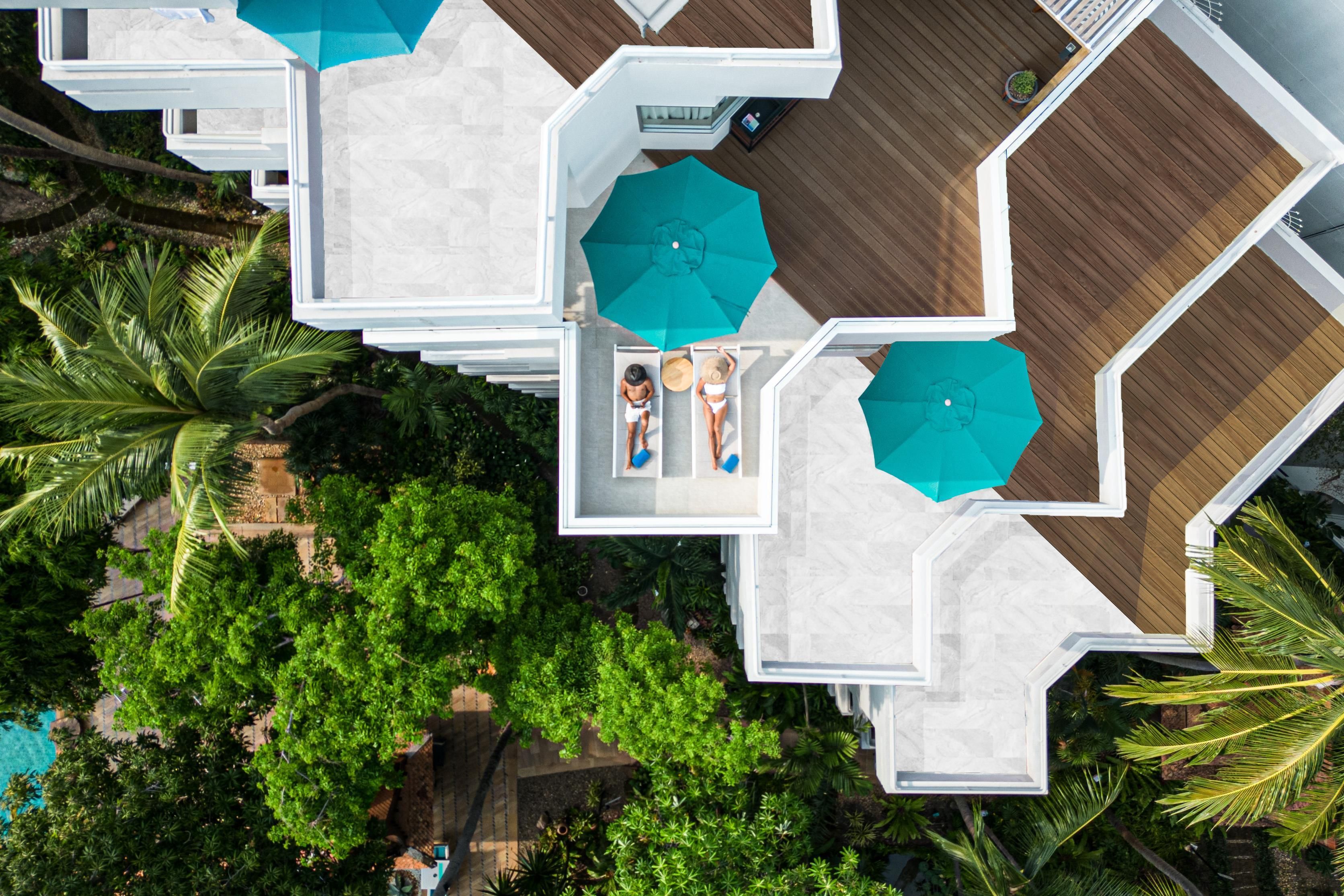A resort with multiple hexagonal structures, each with a pool and a large umbrella.