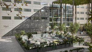 Un hôtel moderne doté d’un jardin sur le toit, d’un espace extérieur aménagé et offrant une vue sur le paysage urbain.