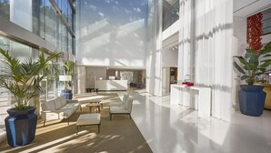 Un hall d’entrée spacieux, doté d’un haut plafond, de grandes fenêtres et de mobilier moderne.