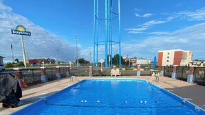 A swimming pool with a metal ladder, a Days Inn sign, and a blue water tower in the background. - Days Inn by Wyndham Perryville (Perryville)