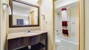A bathroom with a sink, mirror, and a shower area. - Red Roof Inn Augusta - Washington Road (Augusta)