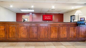 A reception desk with a sign indicating free Wi-Fi in all rooms.