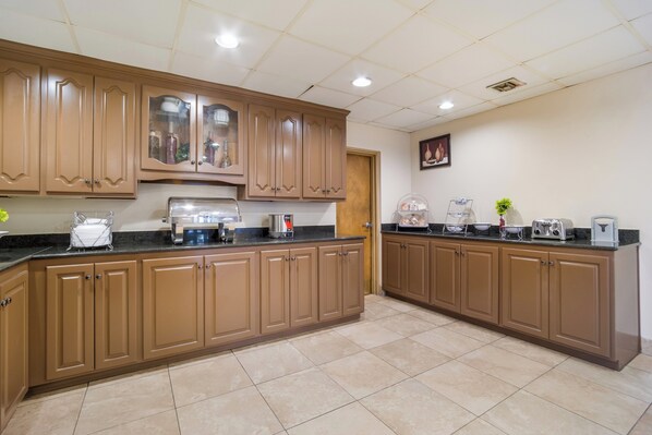 Una cocina con armarios de madera, una cafetera y un tostador.