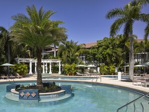 Relax by the serene pool surrounded by lush palm trees and a well-maintained garden.