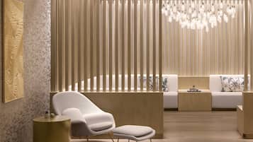 A modern interior with a white sofa, a white chair, and a round gold side table.