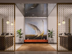Relax in a stylish space with a vibrant sofa, potted plants, and a striking bird painting.