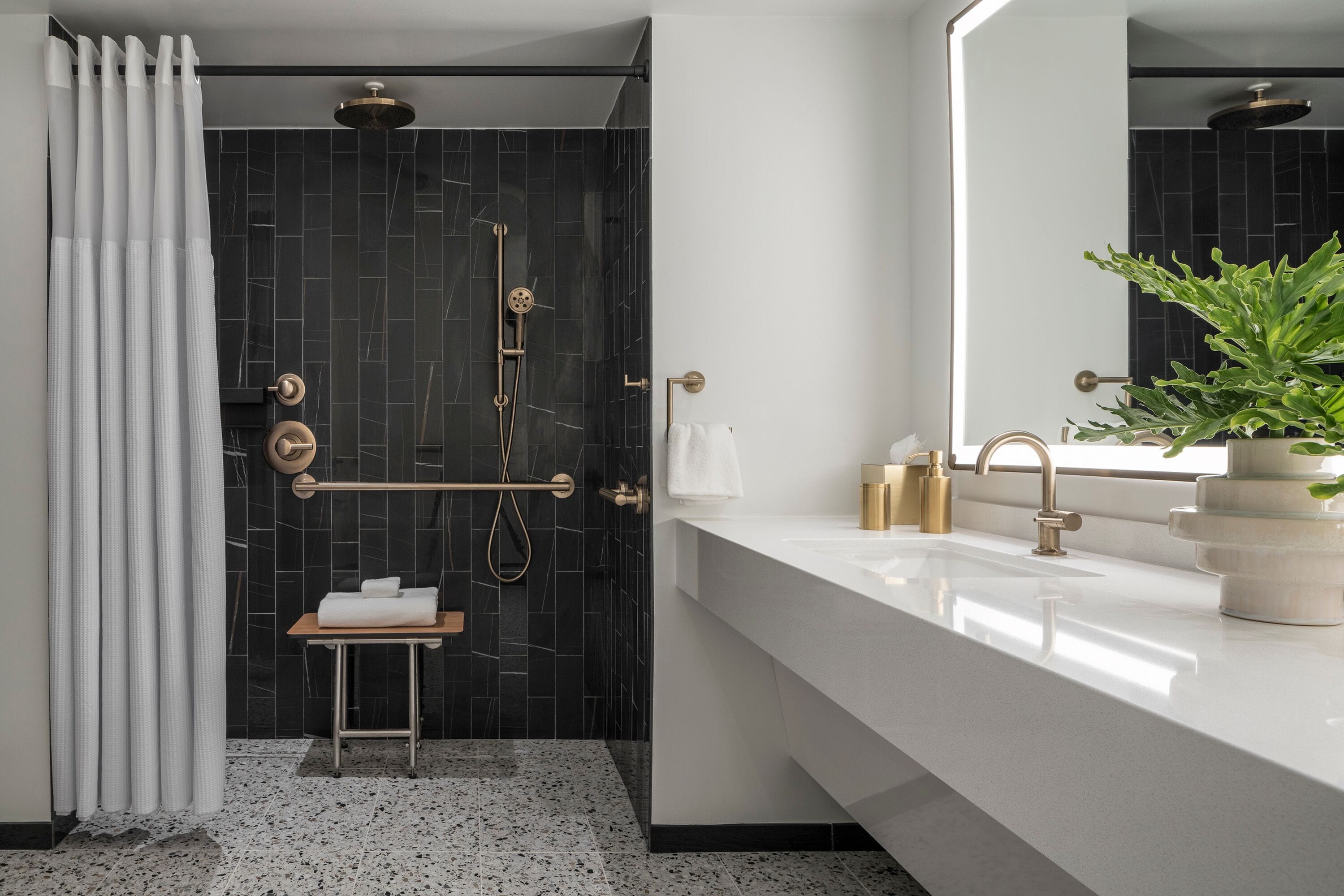 A modern bathroom with a shower, a sink, and a mirror.