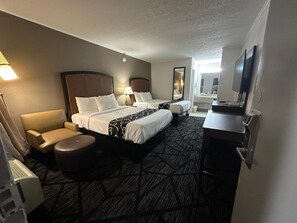 A hotel room with two beds, a desk, a chair, a TV, and a bathroom visible through an open door. - Travel Inn Kingsport (Kingsport)