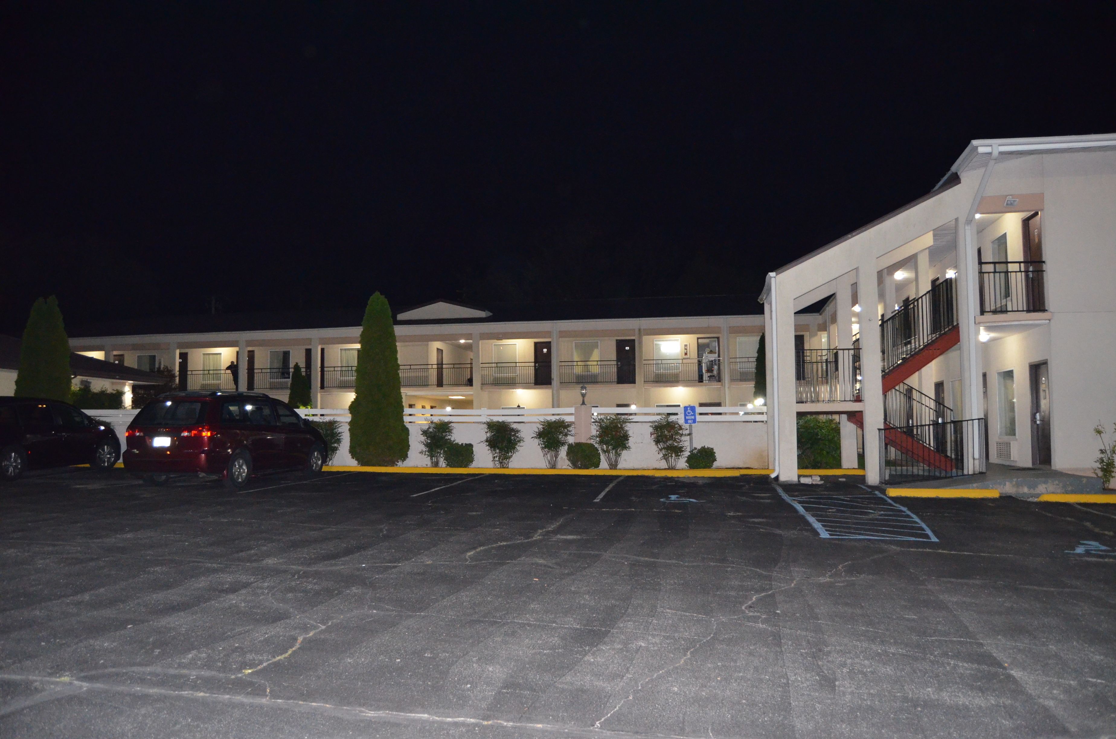 A multi-story hotel with a parking lot, a staircase, and a ramp.