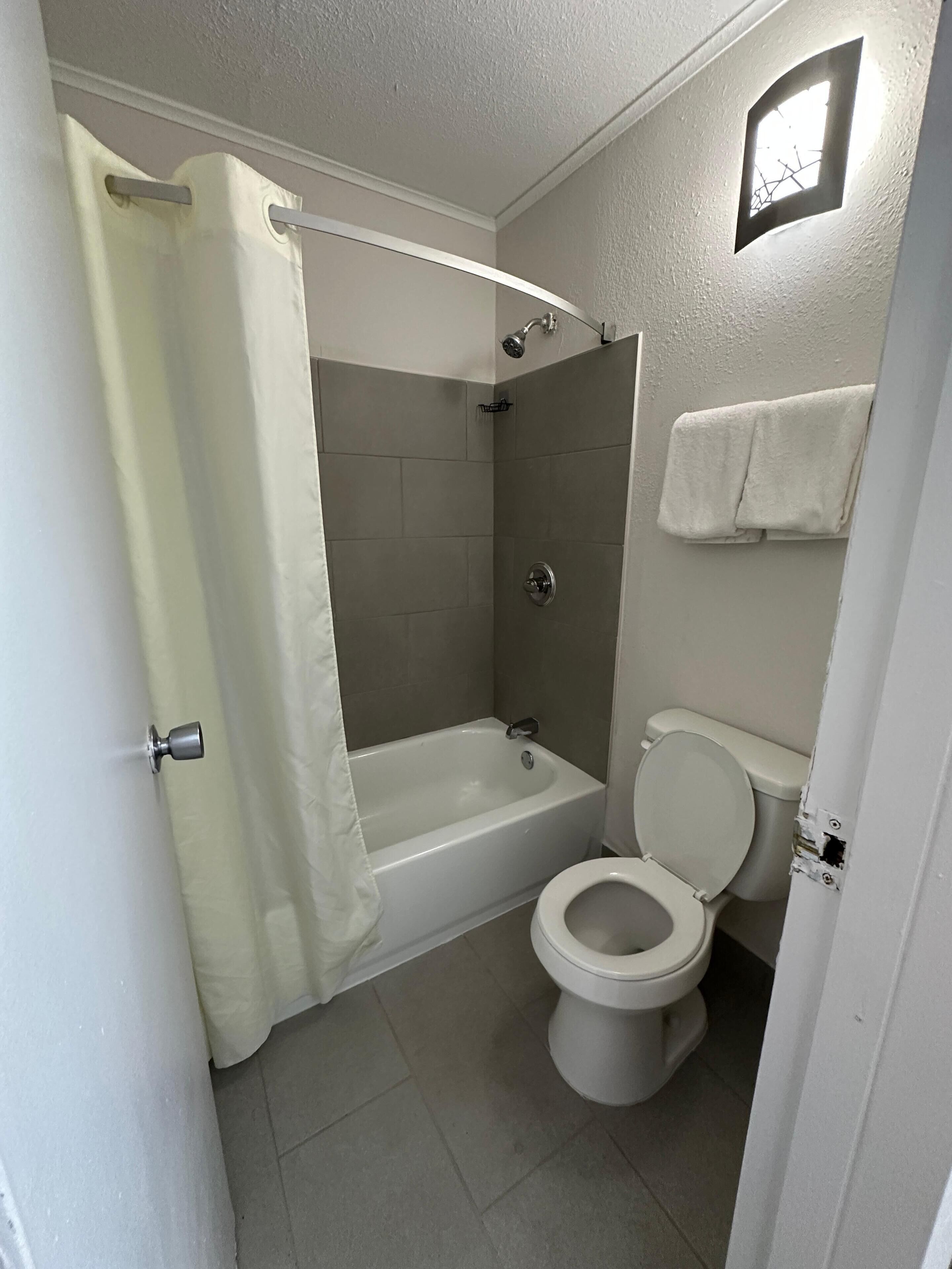 Une salle de bain avec une baignoire, des toilettes et un espace douche.