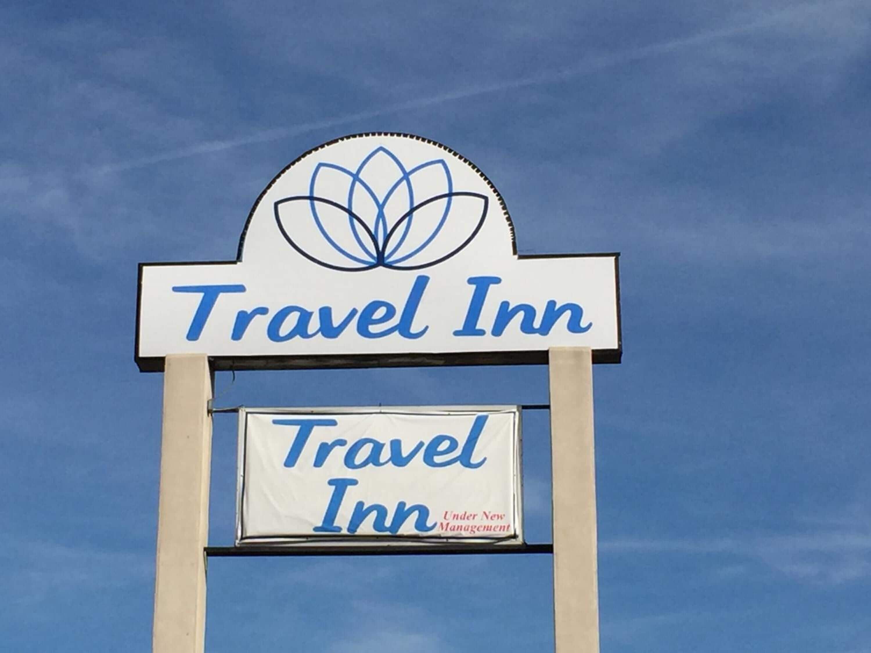 A Travel Inn sign with a logo and the text "Travel Inn Under New Management".