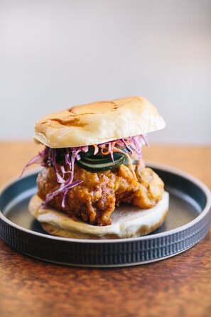 A chicken sandwich with a side of coleslaw on a plate. - Flamingo Resort & Spa Santa Rosa Sonoma, Tapestry by Hilton (Santa Rosa)