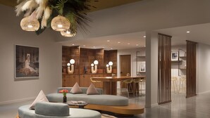 A modern living room with a round coffee table, a sofa, and a dining area with a bar.