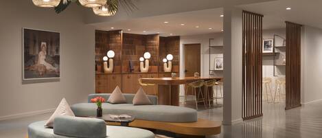 A modern living room with a round coffee table, a sofa, and a dining area with a bar.