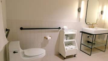 Un bagno con il water, un lavandino, uno specchio e un portasciugamani.