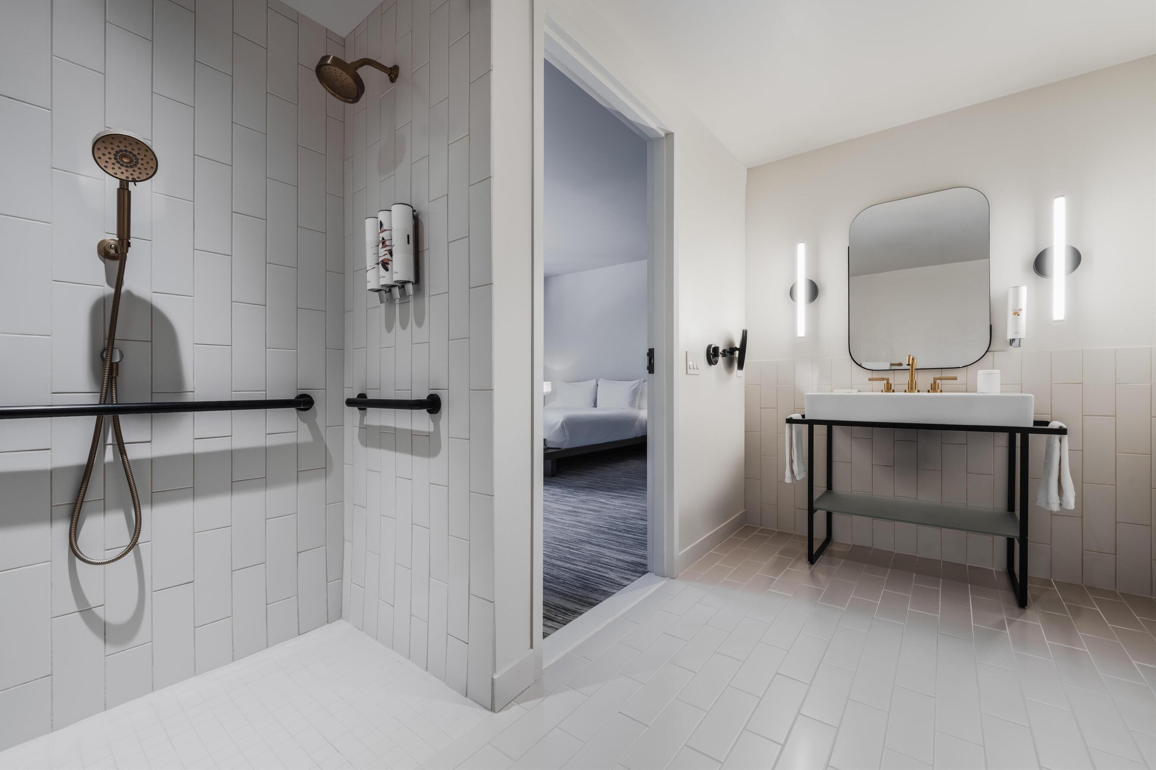A modern bathroom with a shower, toilet, and sink.