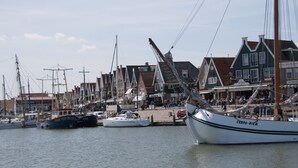 A marina with boats docked, a waterfront promenade, and traditional buildings with gabled roofs. - Hotel Spaander, BW Signature Collection (Volendam)