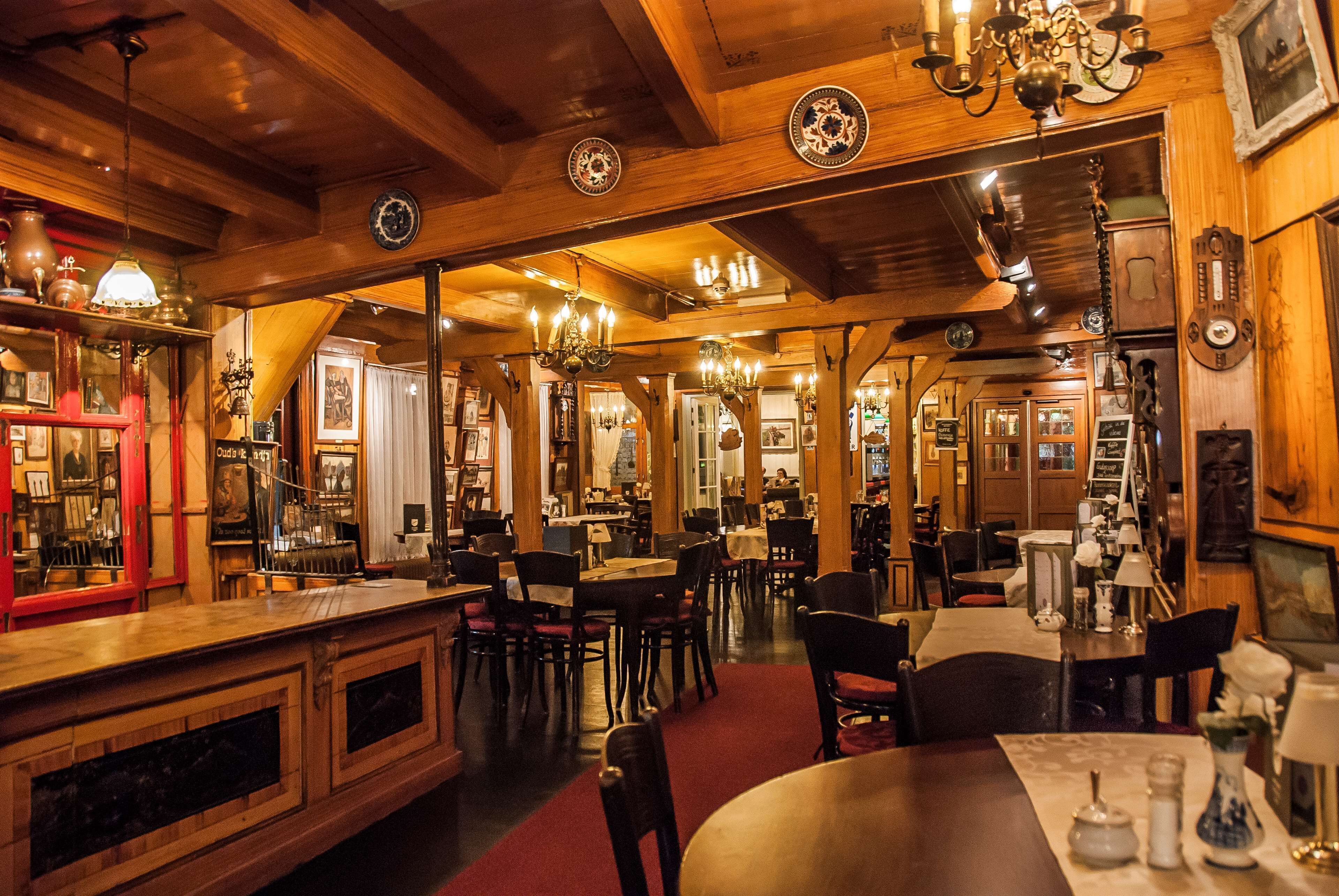 Un ambiente acogedor con paneles de madera, una zona de bar, mesas de comedor y sillas.