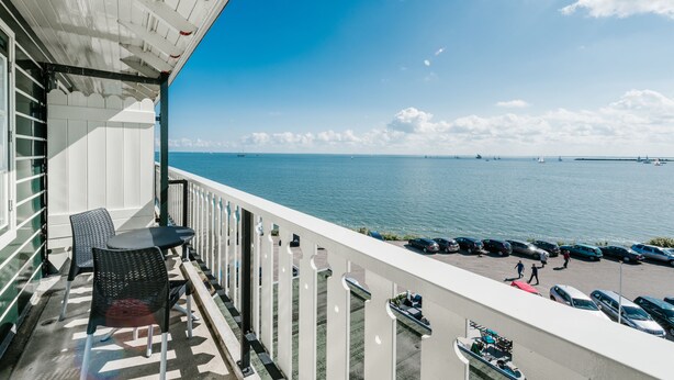 A balcony with a view of the sea, a table, and chairs. - Hotel Spaander, BW Signature Collection (Volendam)