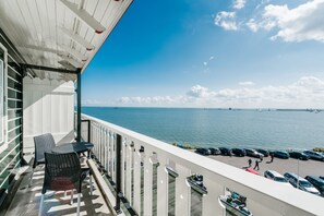 A balcony with a view of the sea, a table, and chairs. - Hotel Spaander, BW Signature Collection (Volendam)