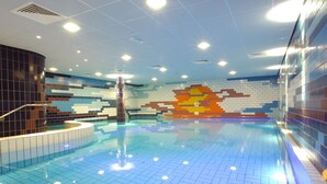 An indoor swimming pool with a tiled floor and walls, a central column, and a colorful mosaic on the back wall. - Hotel Spaander, BW Signature Collection (Volendam)