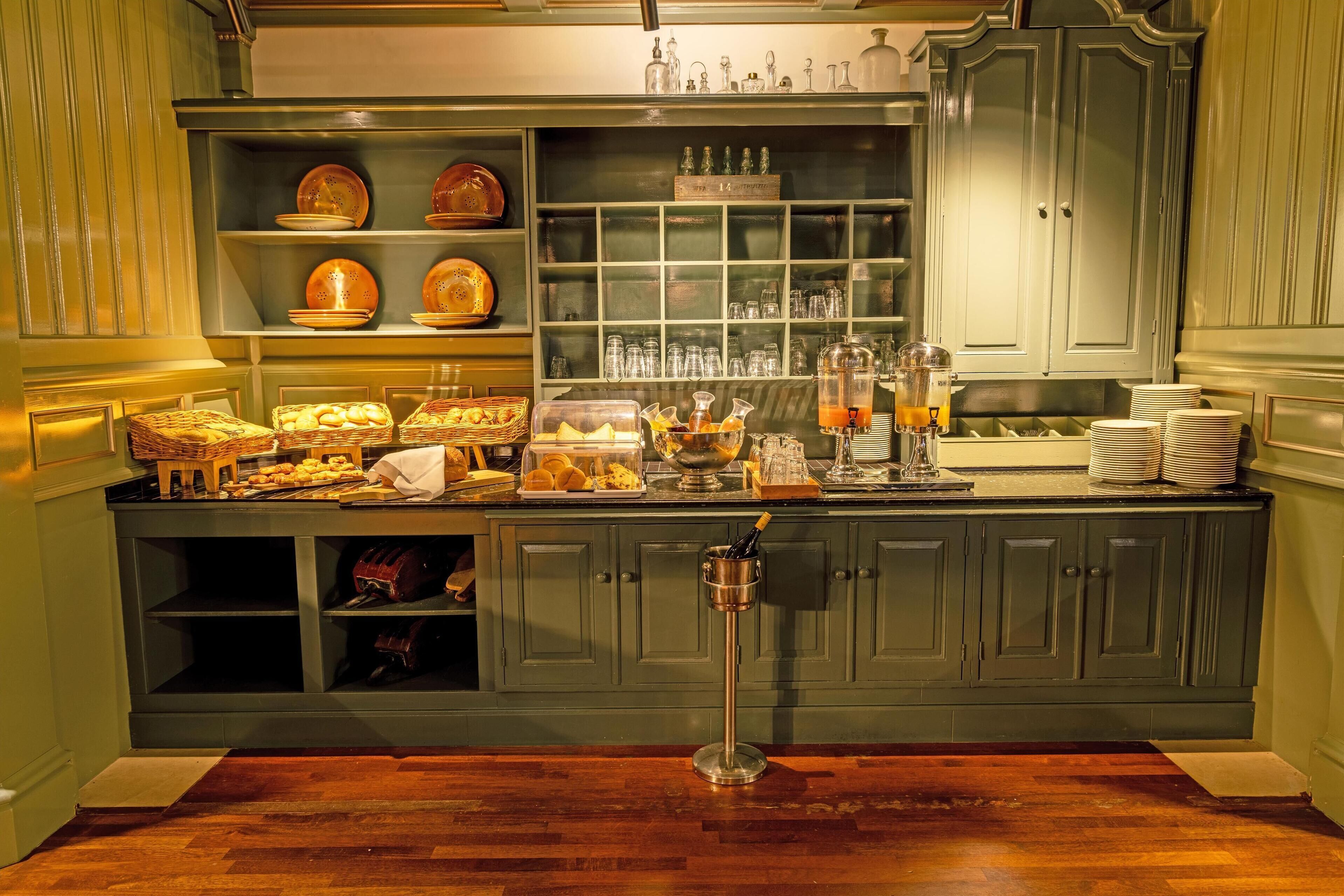 Una cocina con armarios de madera, una encimera con productos alimenticios y un soporte para botellas de vino.