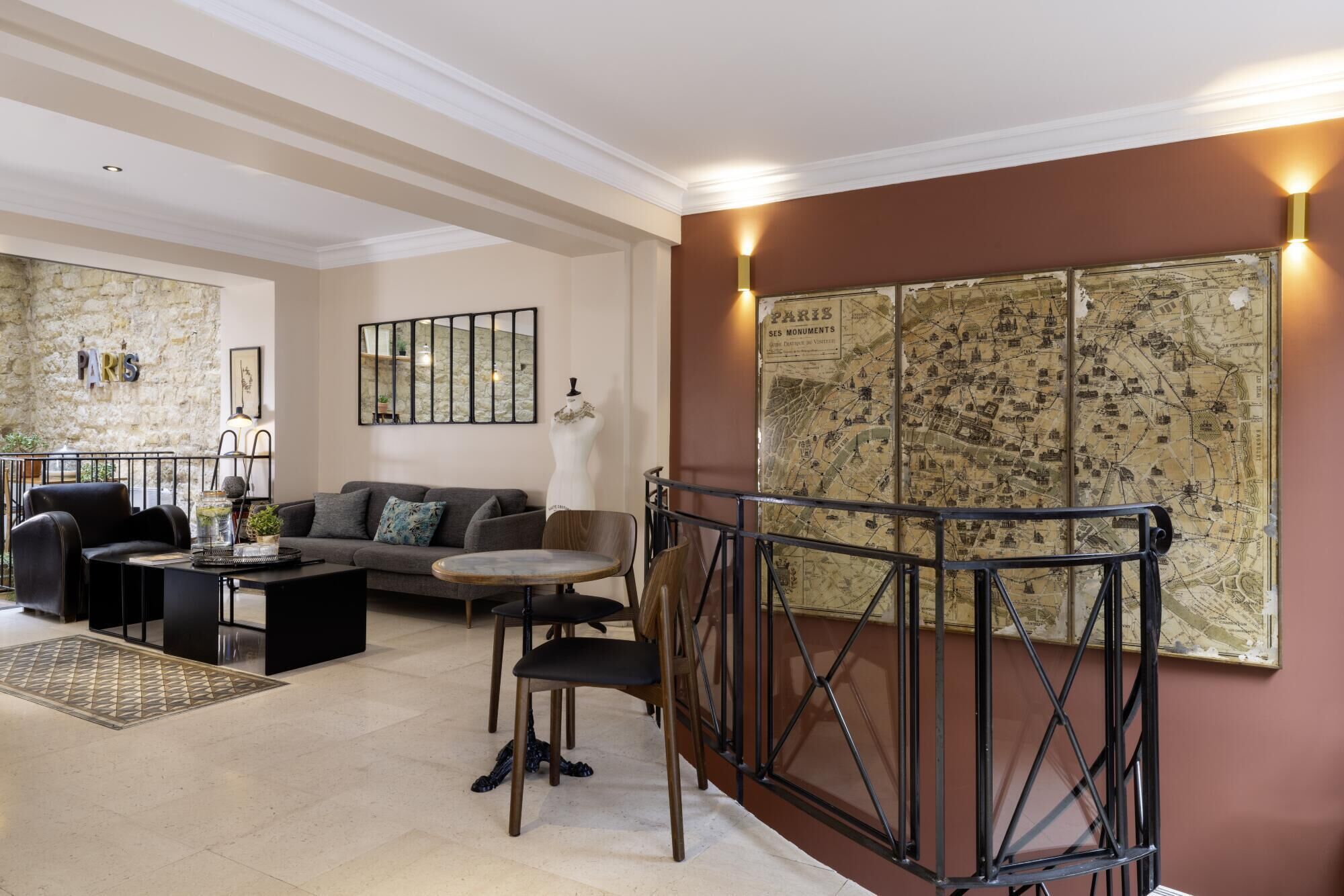 A modern living room with a sofa, chairs, a coffee table, and a map of Paris on the wall.