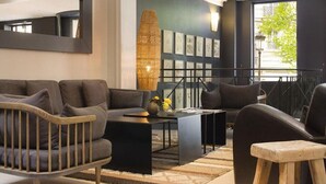 Ein modernes Wohnzimmer mit einer Couch, Sesseln, einem Couchtisch und einer dekorativen Vase.