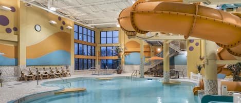 Une piscine intérieure dotée d’un toboggan, d’un toit ouvrant et d’un espace détente.