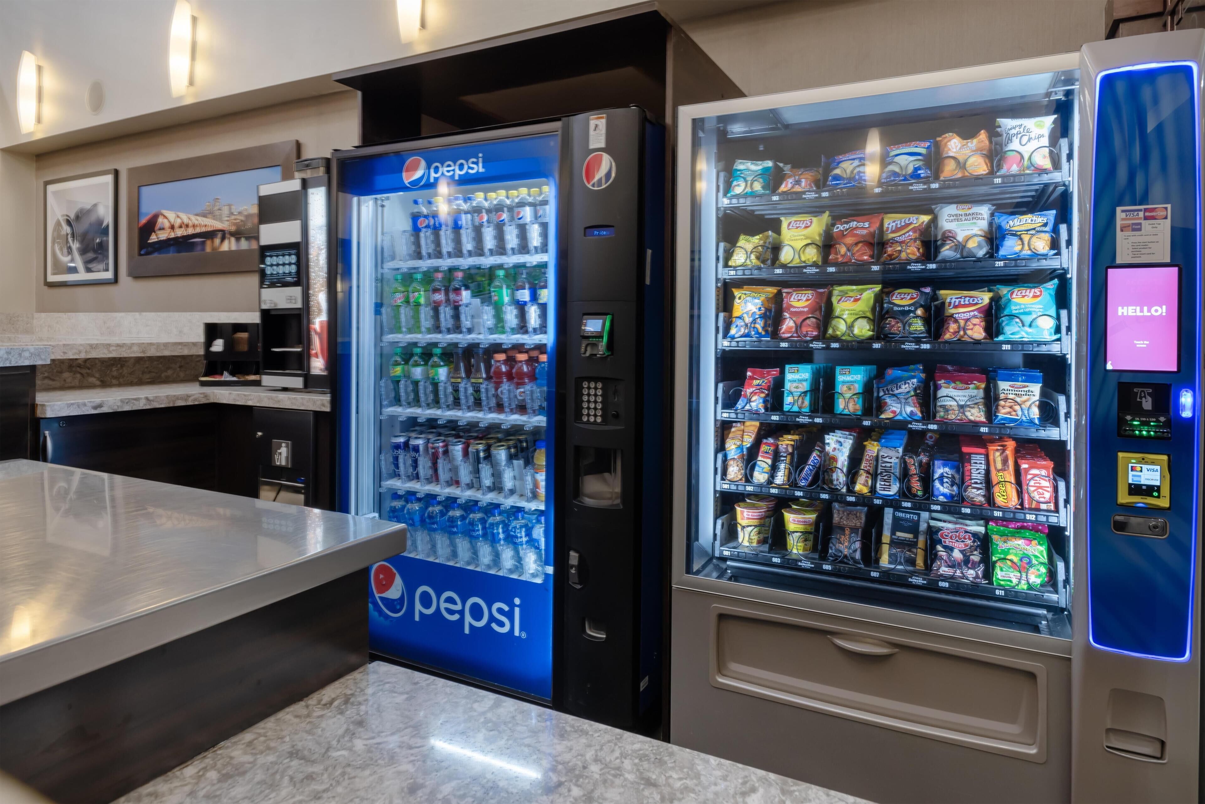 Zona de màquines expenedores amb un refrigerador de Pepsi i una màquina de menjar ràpid.