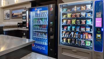 Zona de màquines expenedores amb un refrigerador de Pepsi i una màquina de menjar ràpid.