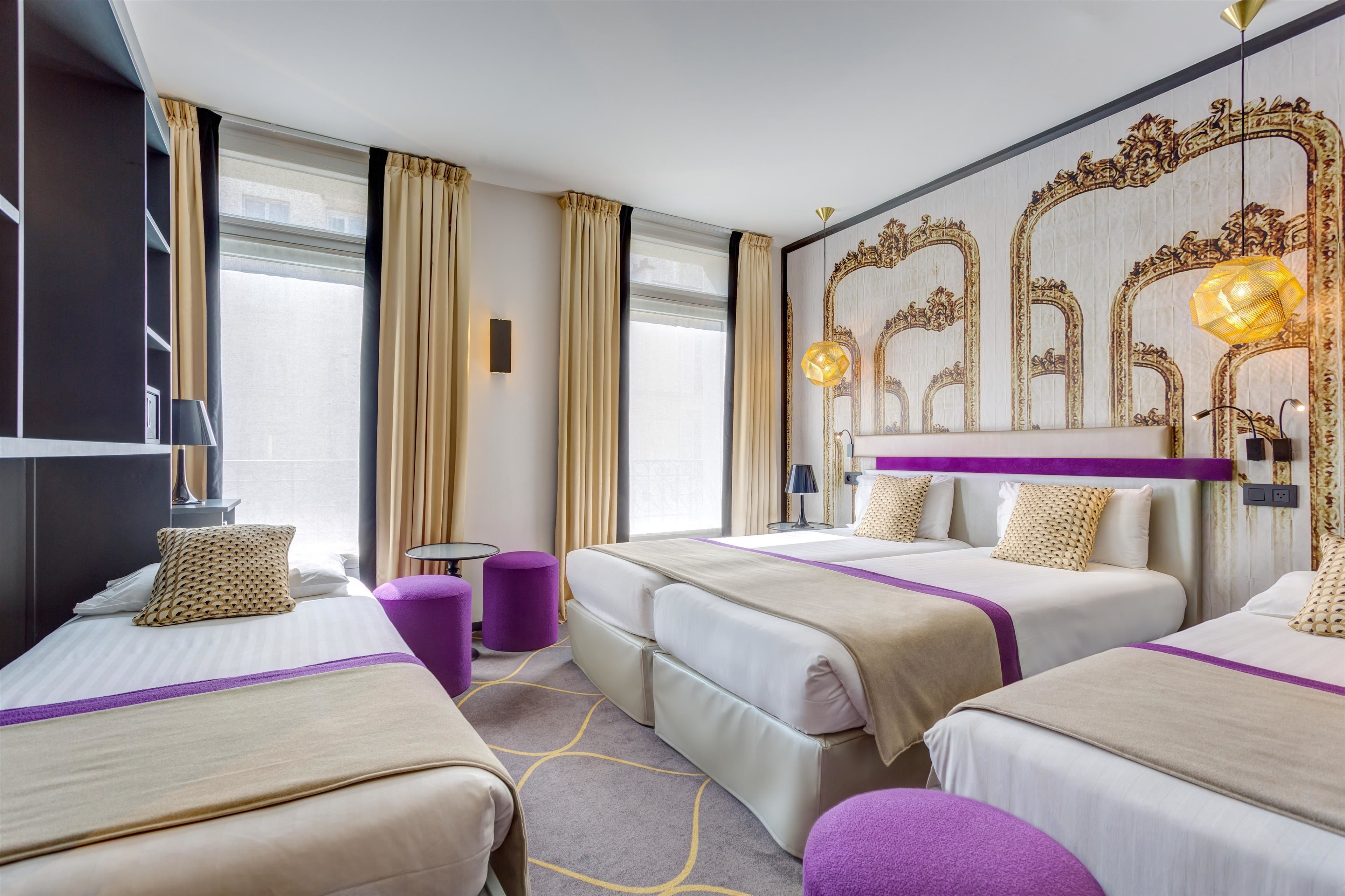 Habitación de hotel con dos camas, un espejo grande y vistas a la ciudad.