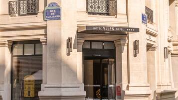 Entrada de um hotel com uma placa que diz 'Hôtel Vallen Eiffel'.