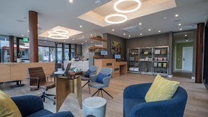 Un espacio de oficina moderno con una recepción, zona de estar y exhibición de productos.
