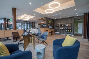 Un espacio de oficina moderno con una recepción, zona de estar y exhibición de productos.