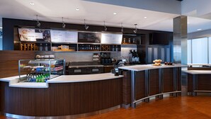 Un espace bar moderne doté d’un comptoir, de panneaux d’affichage présentant le menu et proposant une variété de boissons.
