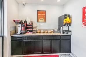 Enjoy a convenient breakfast with a coffee machine, toaster, and fruit juice dispenser in this compact kitchenette.