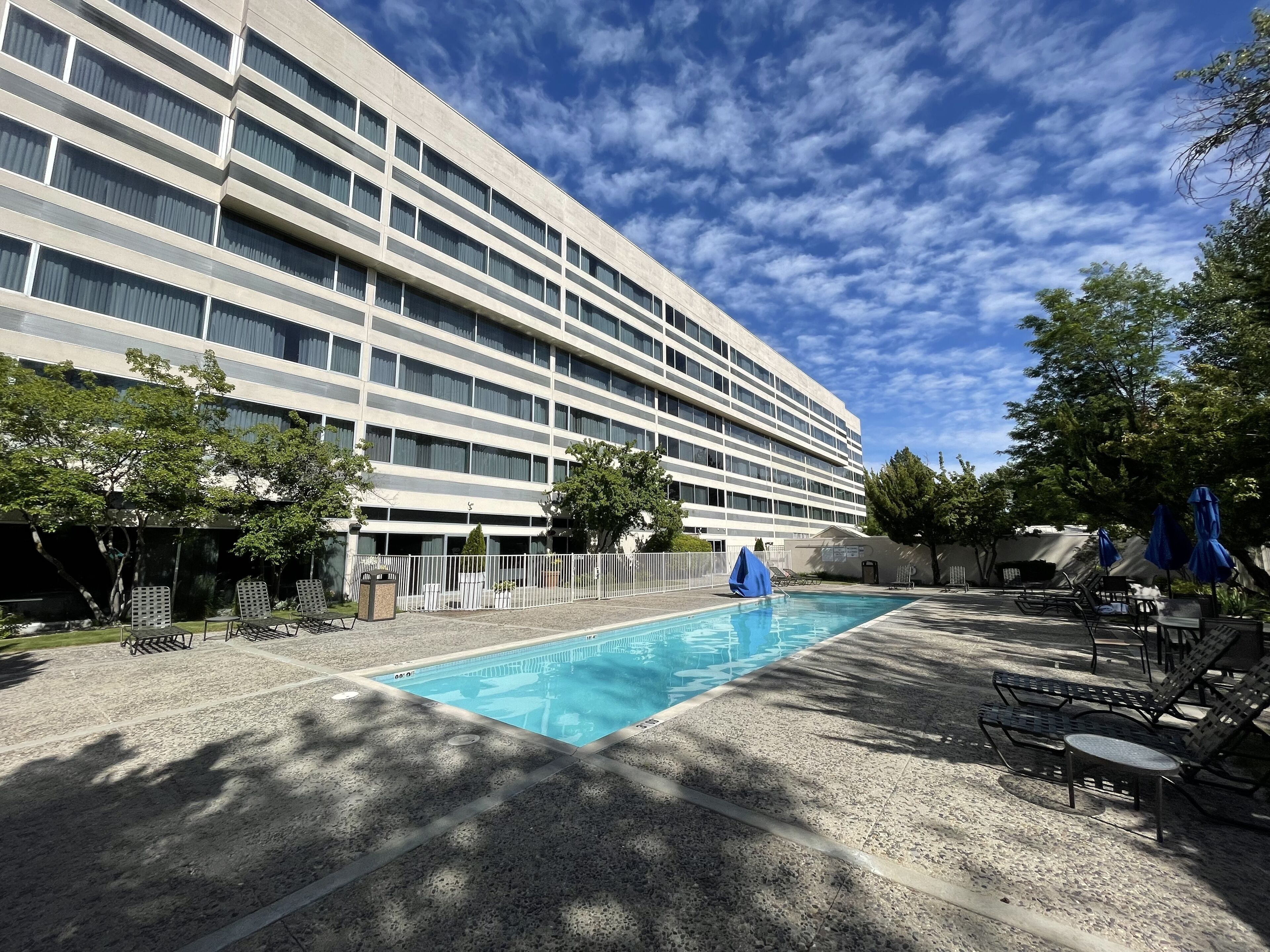 Un hôtel doté d’une piscine, d’un espace extérieur aménagé et d’un grand bâtiment à plusieurs étages.