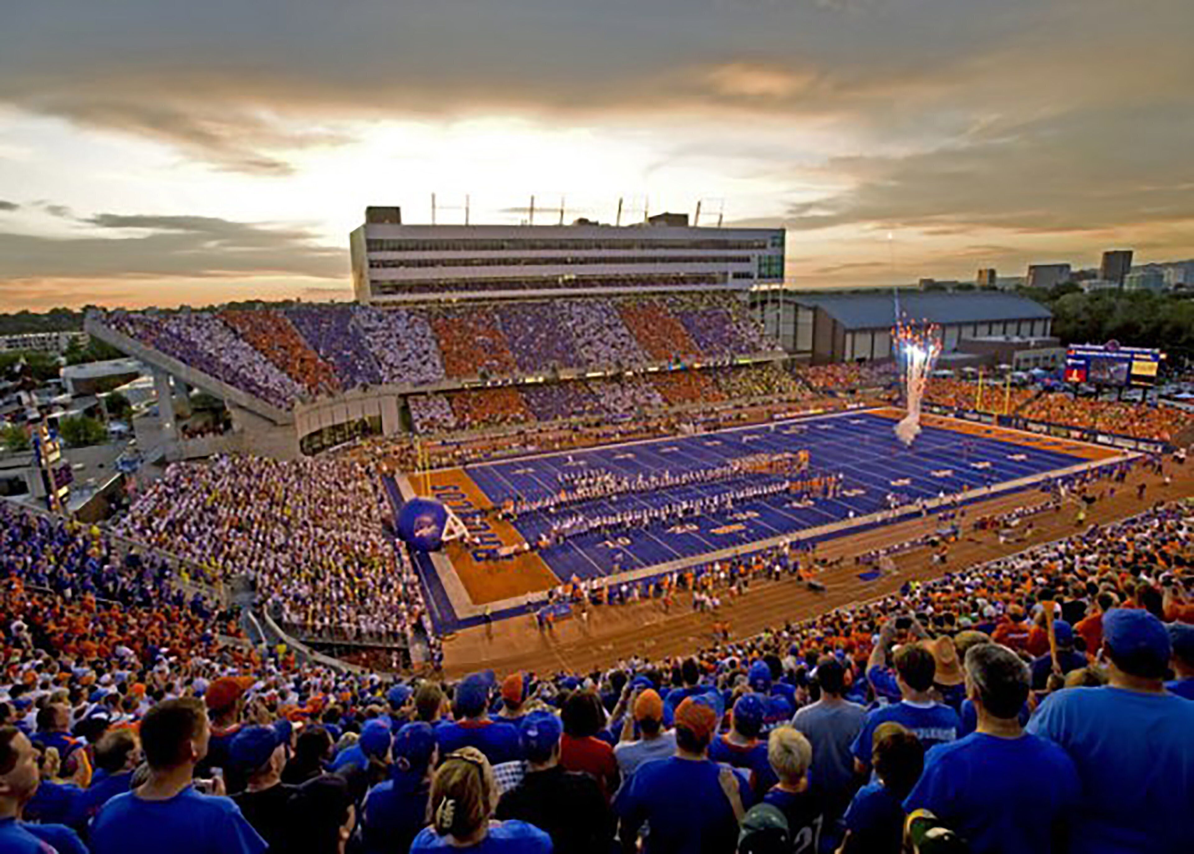 A large stadium with multiple tiers of seating and a central field.