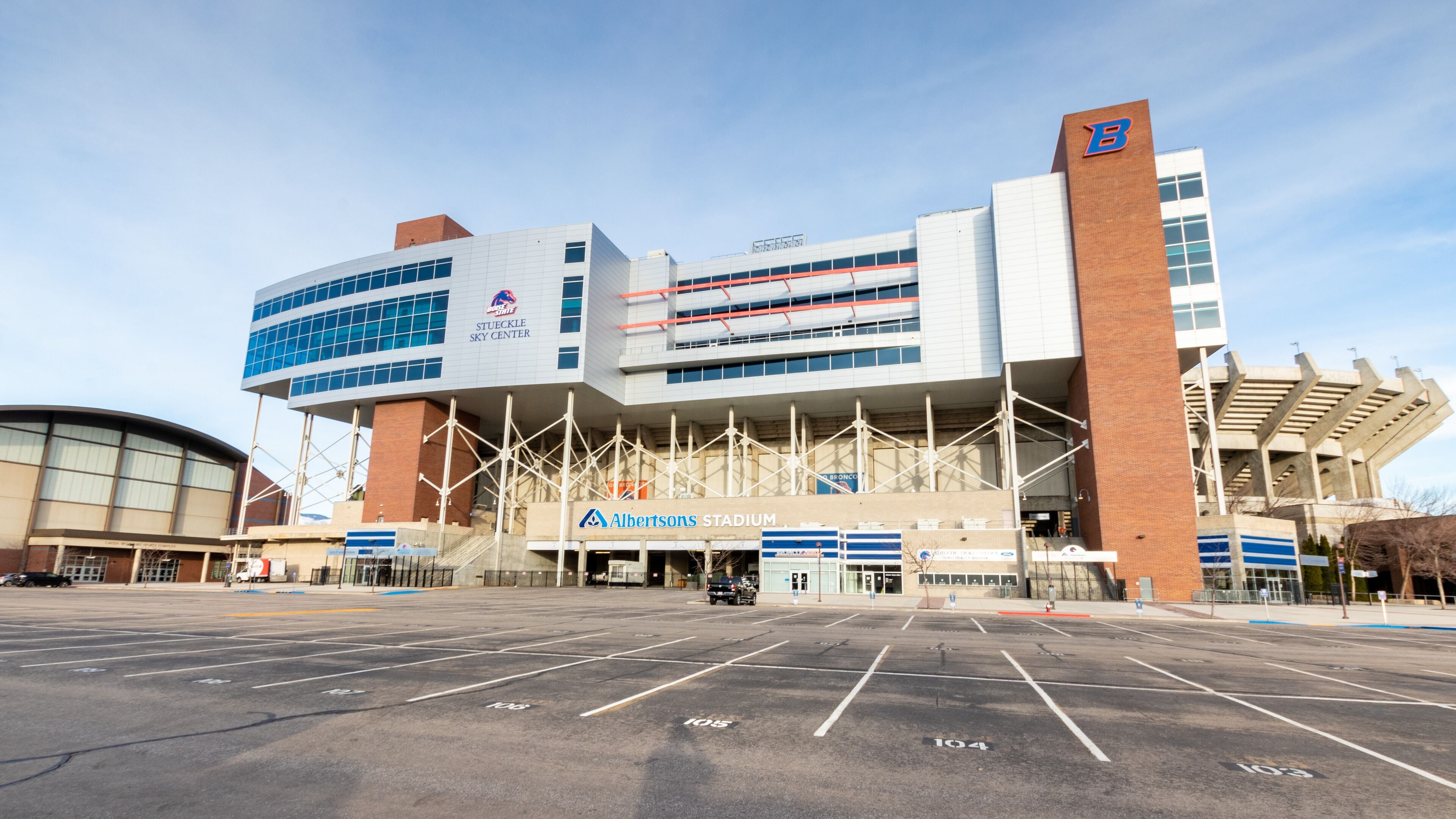 Albertsons Stadium mit deutlicher Beschilderung, einem Parkplatz und modernem architektonischem Design.