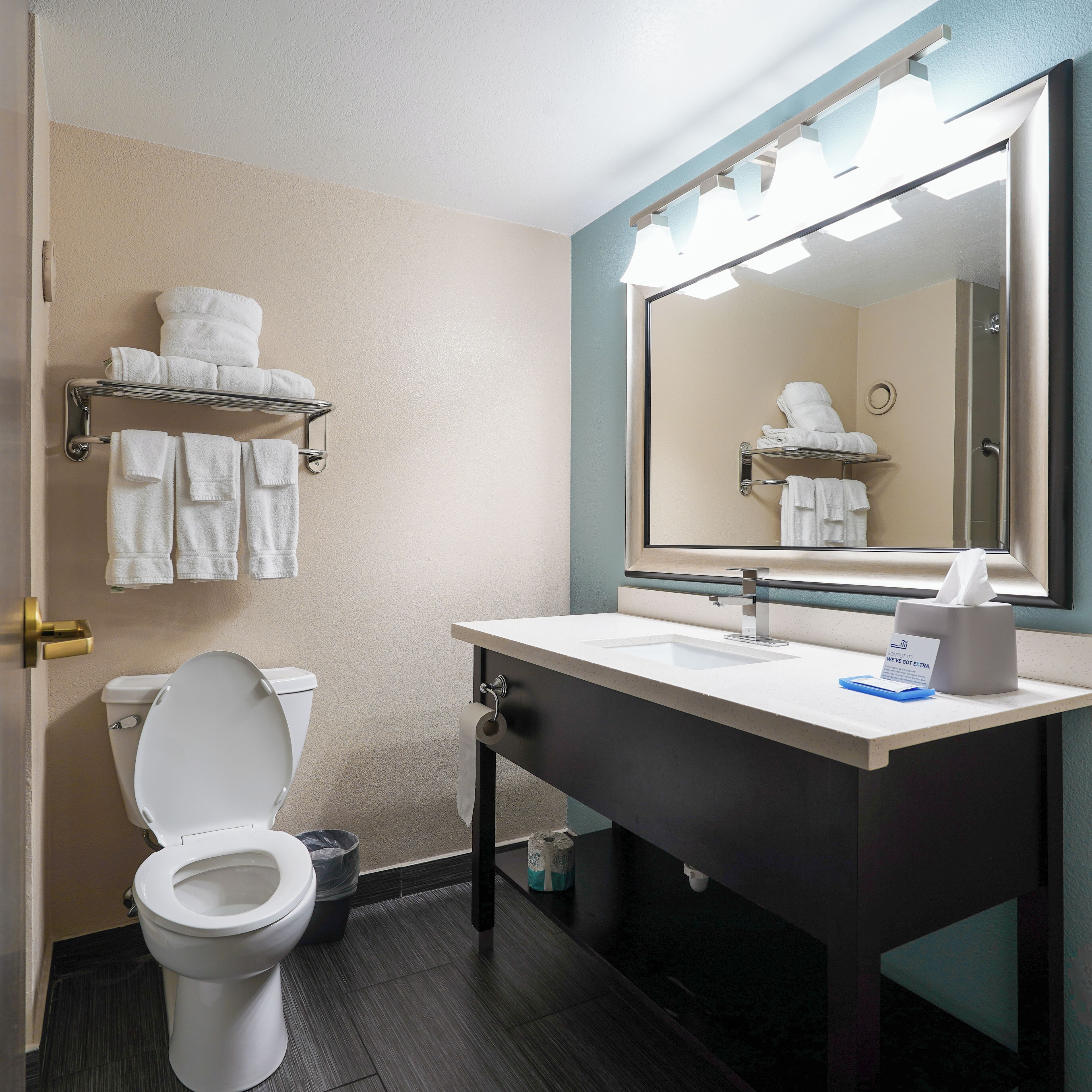 A modern bathroom with a toilet, sink, and towel rack.